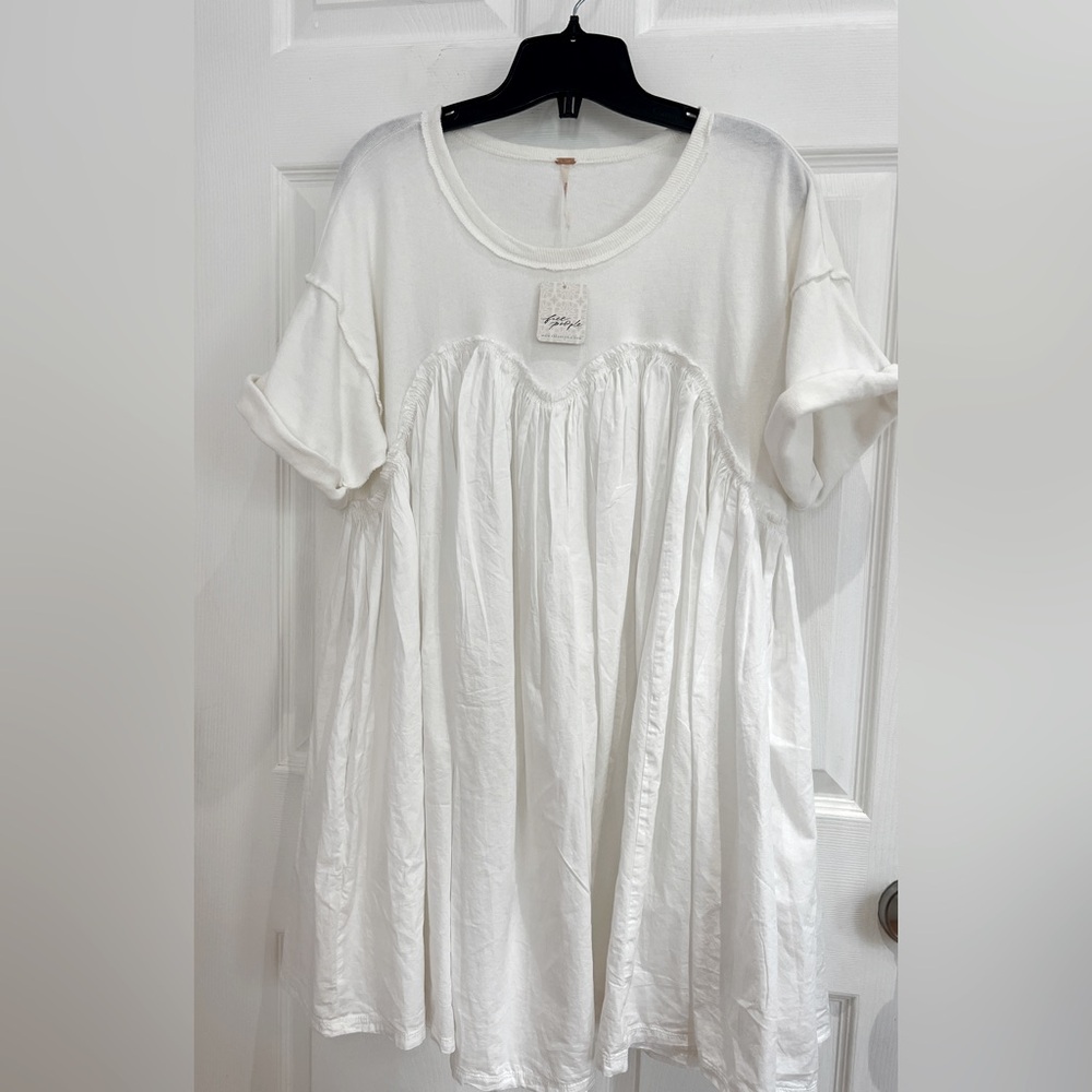 Free People white cotton mini dress with cuff sleeves and a flouncy finish.